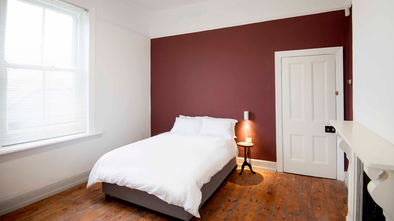 Empty maroon accent wall in a bedroom