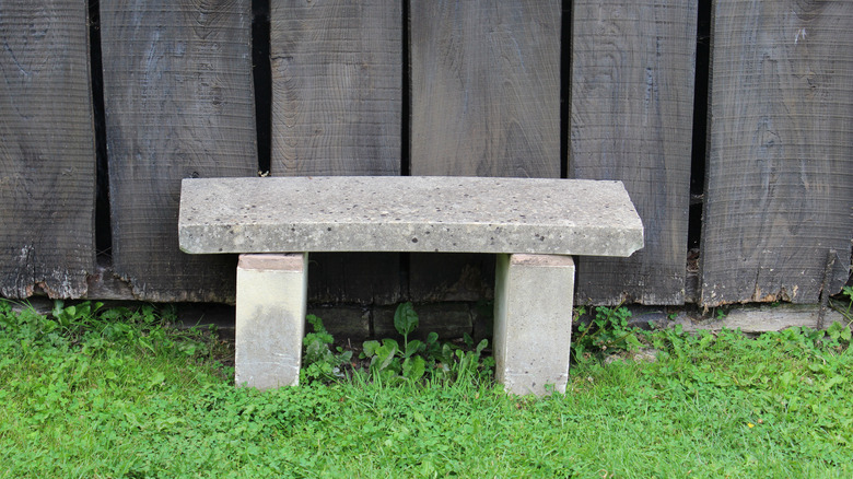 DIY concrete bench against a fence