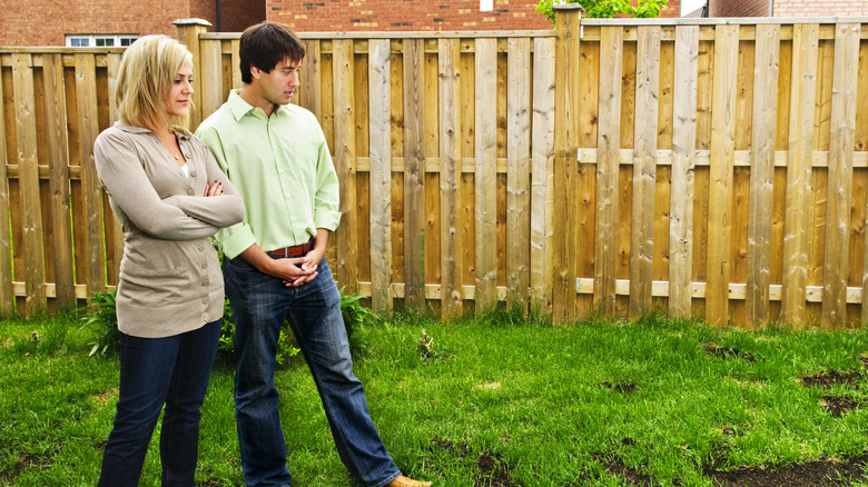 Couple looks at backyard grass