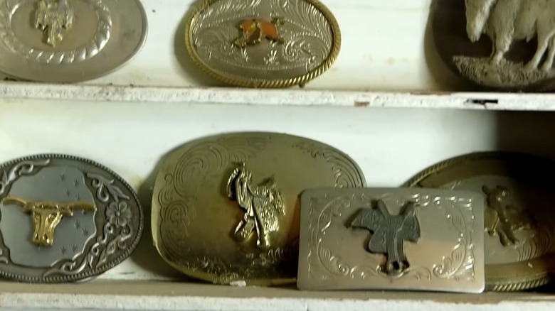 Vintage belt buckles on an old shelf
